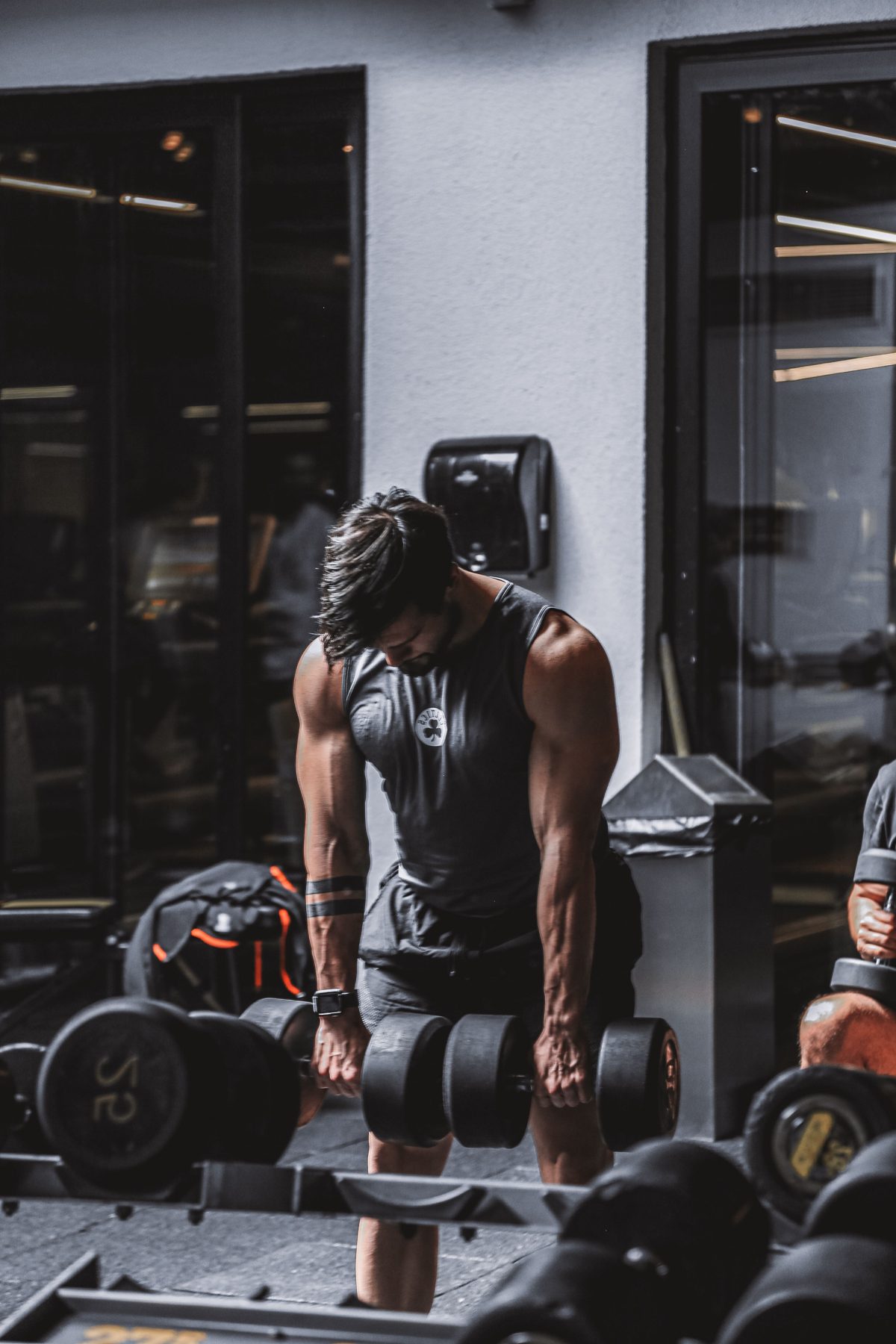 A member lifting heavy dumbbells from the floor