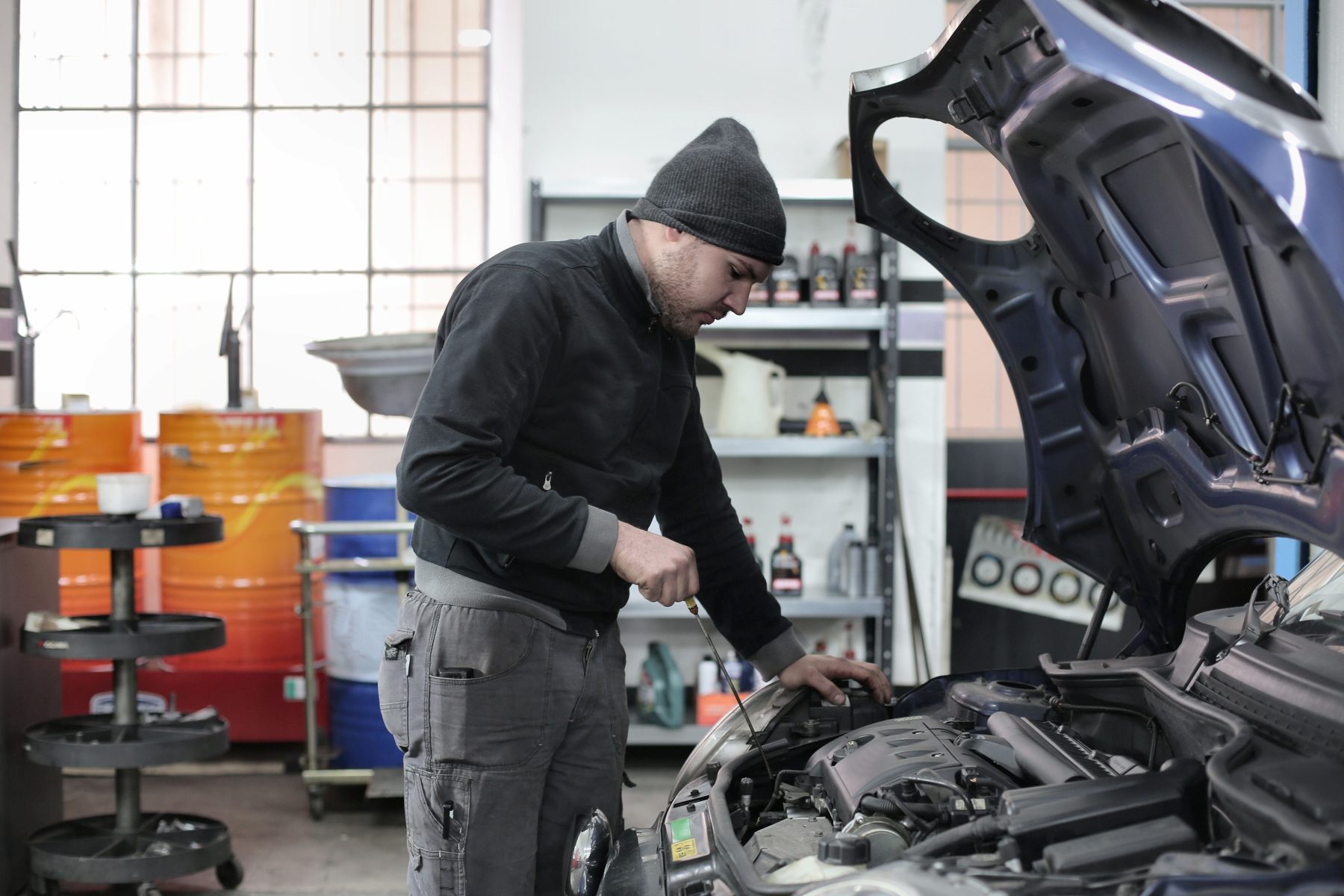 A mechanic checking an engine with the bonnet raised