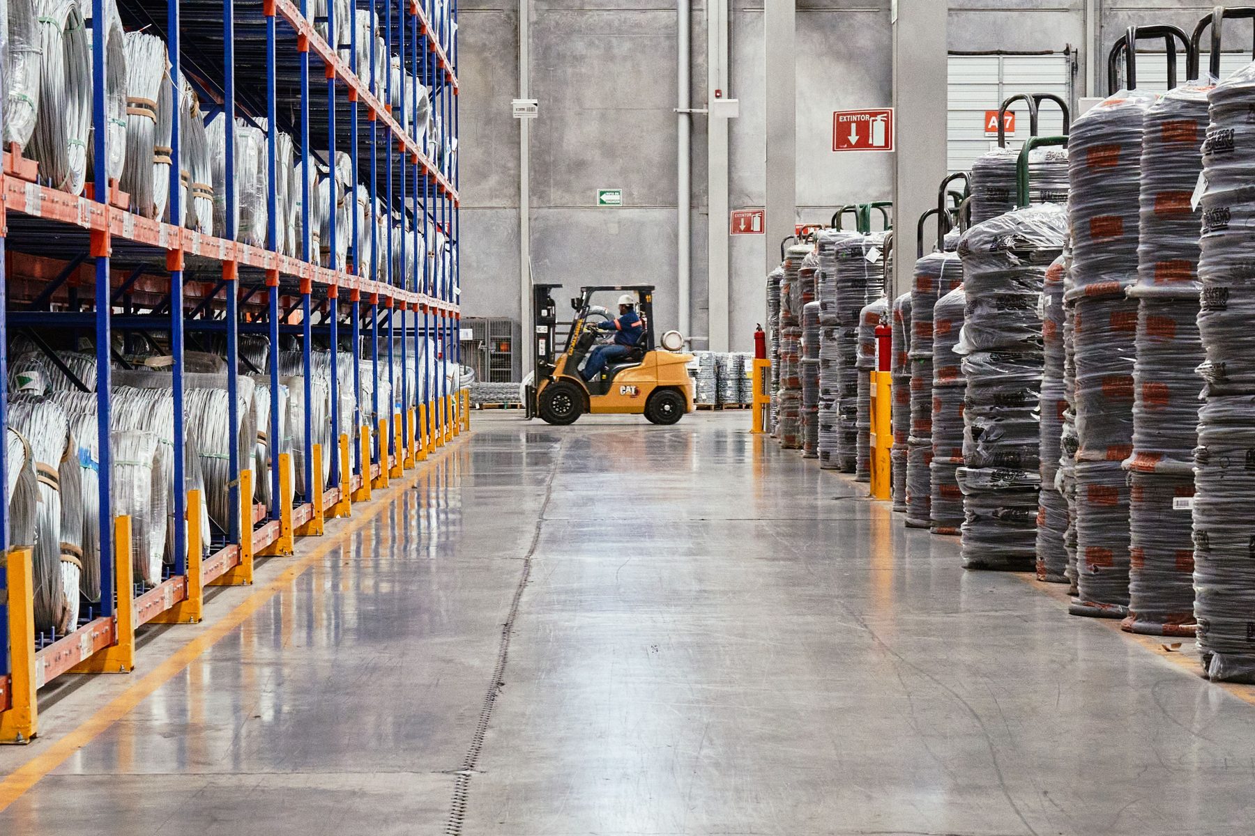 A forklift working in a racked warehouse aisle